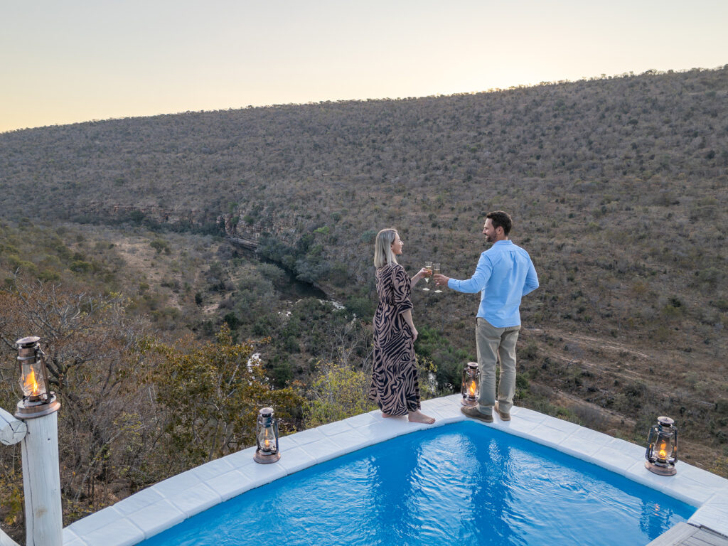Clifftop Exclusive Safari Hideaway couple with sundowners at pool