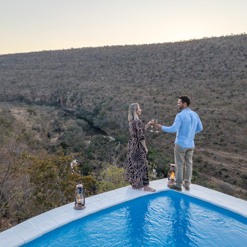 Clifftop Exclusive Safari Hideaway couple with sundowners at pool